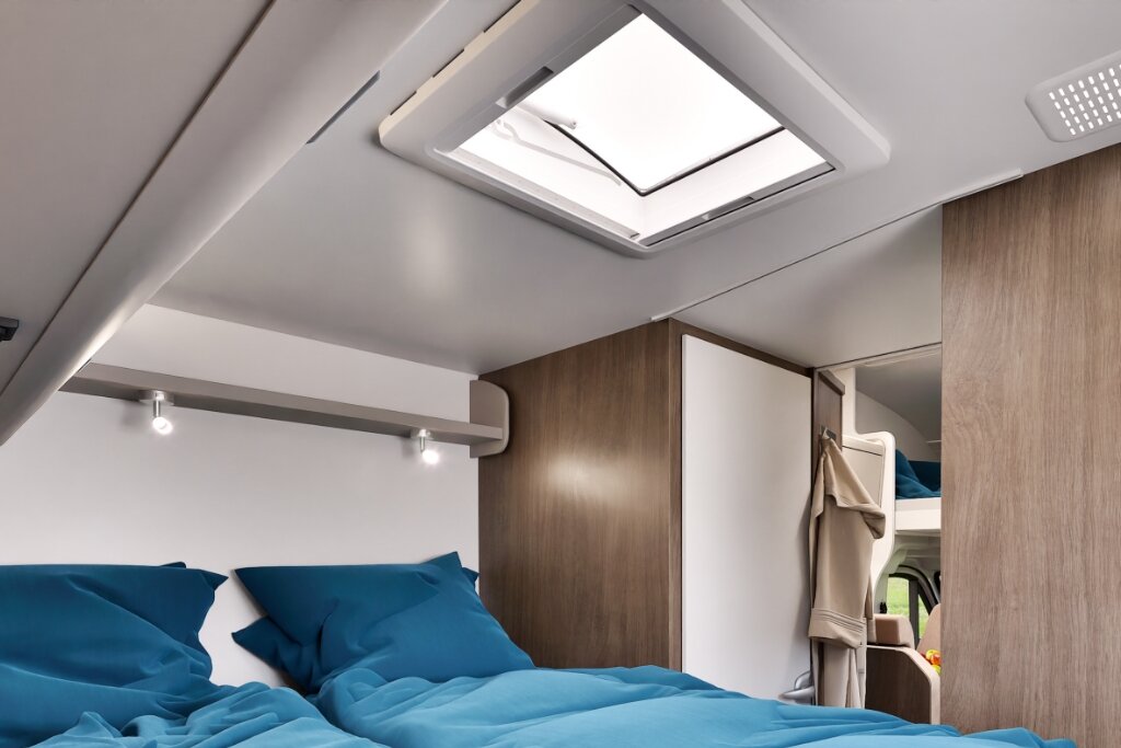 Schlafbereich im Carado Wohnmobil mit Doppelbett, Dachfenster und Schrank