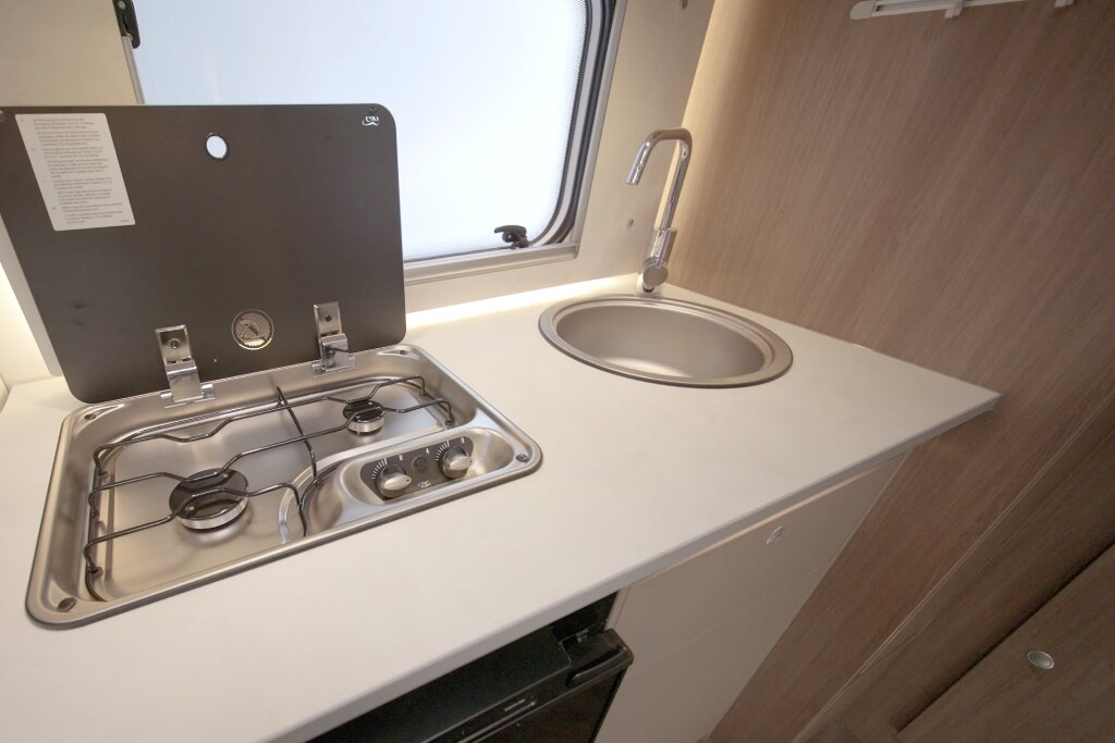 Küche im Carado Wohnmobil mit zweiflammigem Gasherd, runder Spüle und Arbeitsfläche