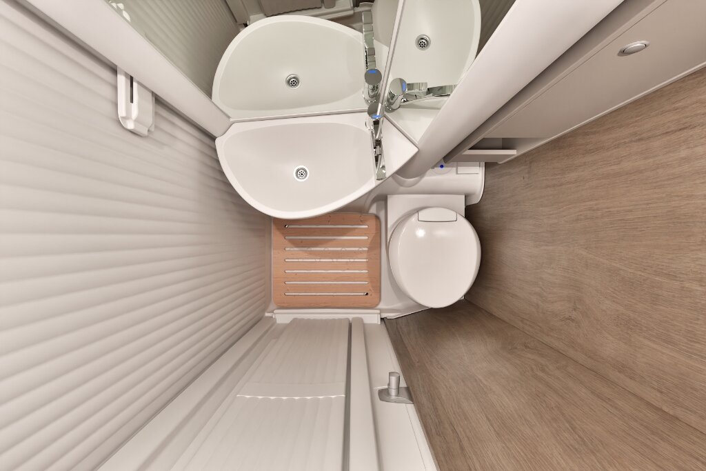 Badezimmer im Carado Wohnmobil mit Waschbecken, Spiegel, Toilette und Duschrost in kompakter Nasszelle