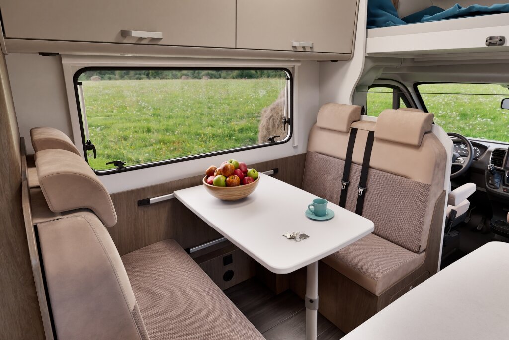 Sitzgruppe im Carado Wohnmobil mit Tisch, Längsbank, drehbaren Fahrerhaussitzen und großem Seitenfenster