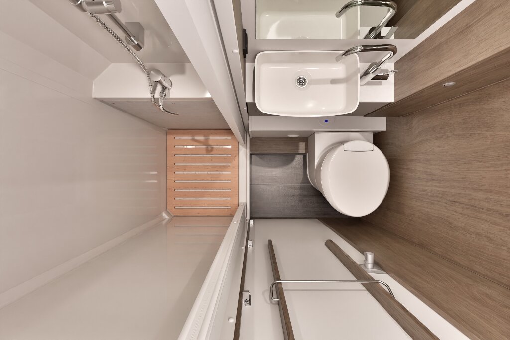 Bad im Carado Wohnmobil mit Dusche, Waschbecken, Toilette und Holzrost