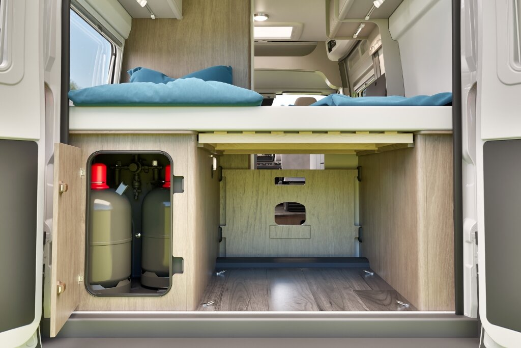 Heckstauraum im Carado Wohnmobil unter Doppelbett mit geöffneter Gasflaschenklappe und Blick in den Innenraum