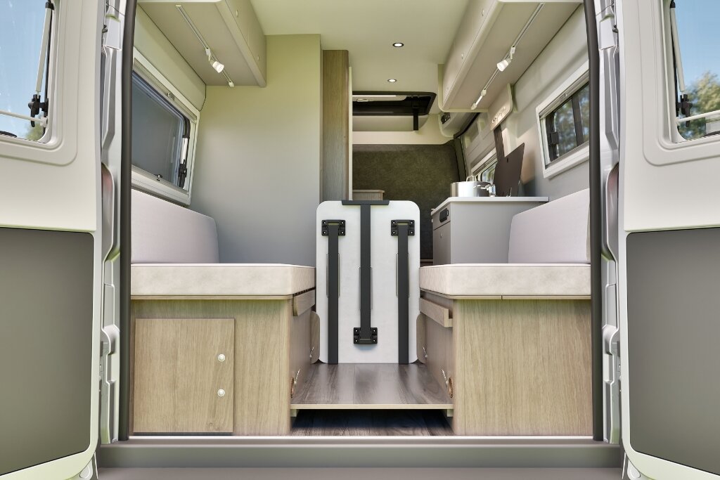 Innenraum Carado Wohnmobil mit zwei Längsbänken, Klapptisch und Küchenzeile, Blick durch geöffnete Hecktüren