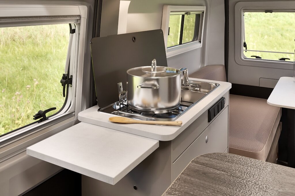 Küche im Carado Wohnmobil mit Gasherd, Kochtopf, Spüle und ausklappbarer Arbeitsfläche