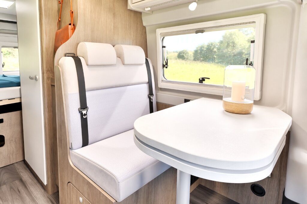 Sitzgruppe im Carado Wohnmobil mit Zweierbank, Tisch und Fenster