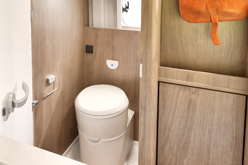 Bad im Carado Wohnmobil mit Kassettentoilette, Holzdekor und Stauraum