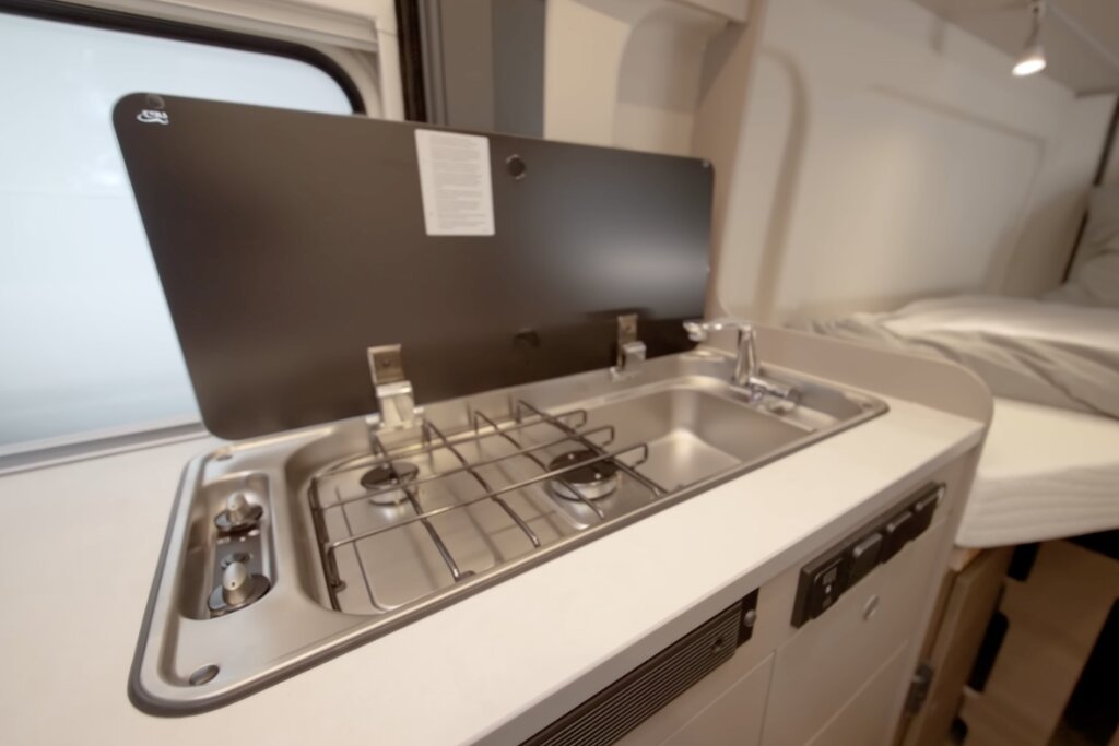 Küchenzeile im Carado Wohnmobil mit Gasherd, Spüle und Glasabdeckung