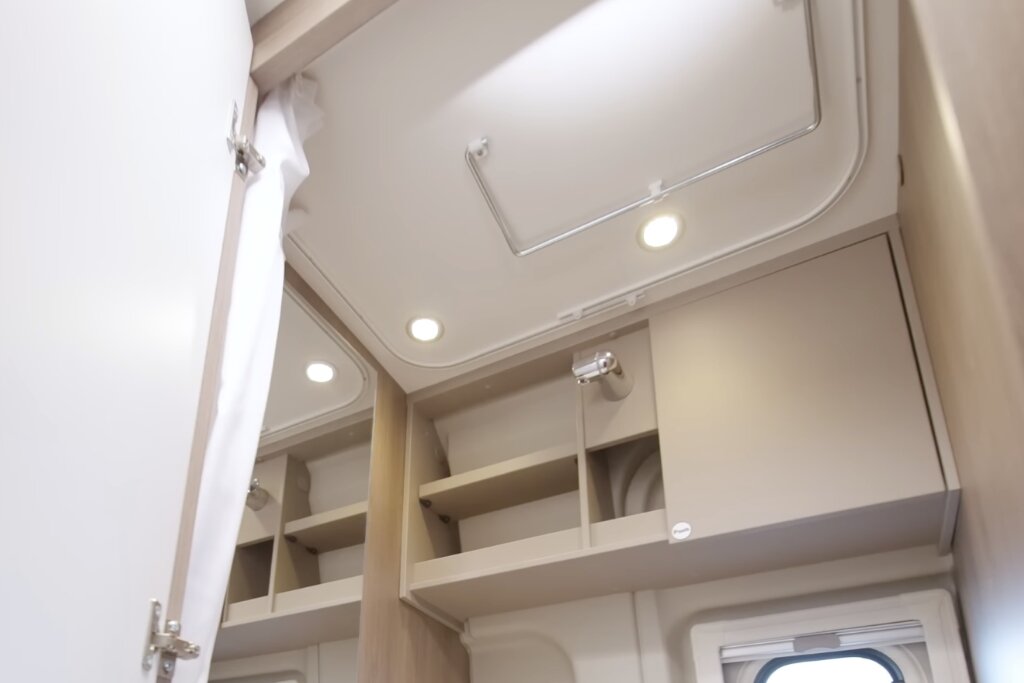 Stauraumschränke im Carado Wohnmobil mit offenen Fächern, Deckenleuchten und Dachluke im Innenraum
