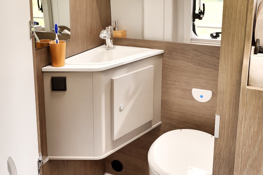 Bad im Carado Wohnmobil mit Eckwaschbecken, Spiegel, Zahnputzbechern und Toilette