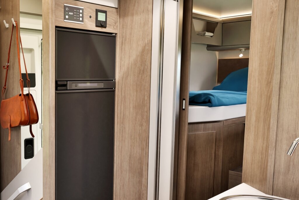 Innenraum Carado Wohnmobil mit hohem Kühlschrank und Schlafbereich im Heck