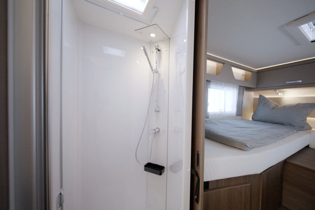 Carado Wohnmobil mit Duschkabine und Schlafbereich mit Doppelbett im Innenraum