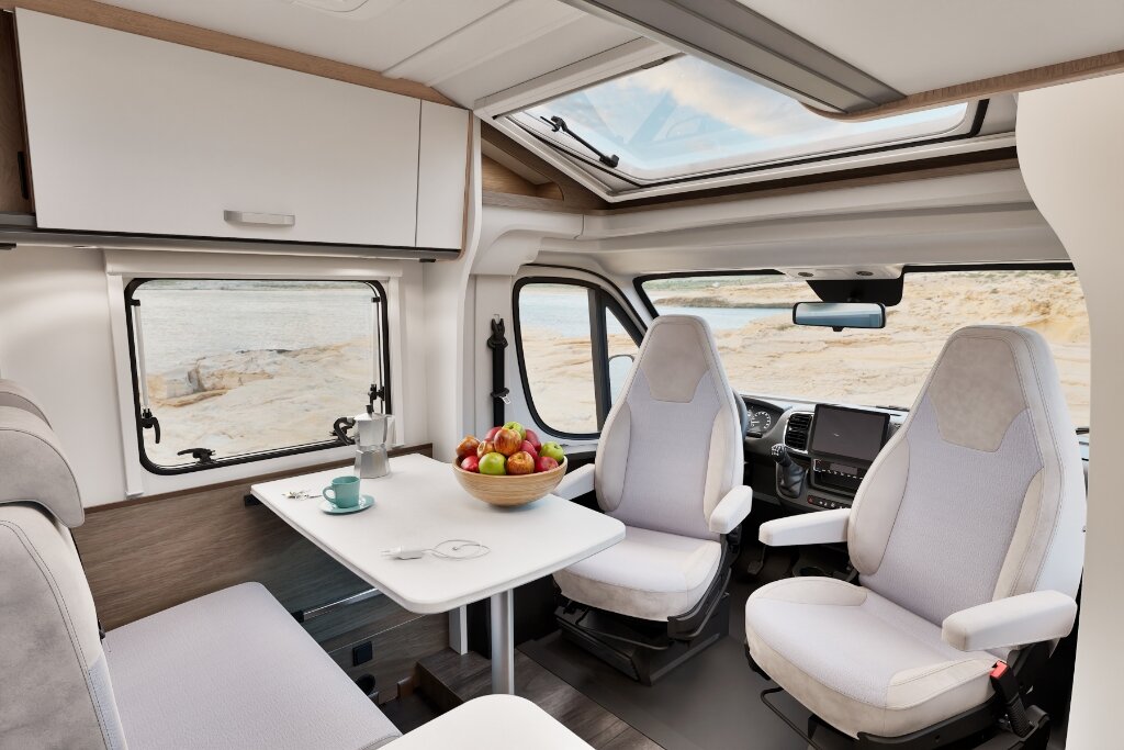 Innenraum Carado Wohnmobil mit Sitzgruppe, drehbaren Fahrersitzen, Tisch und Dachfenster