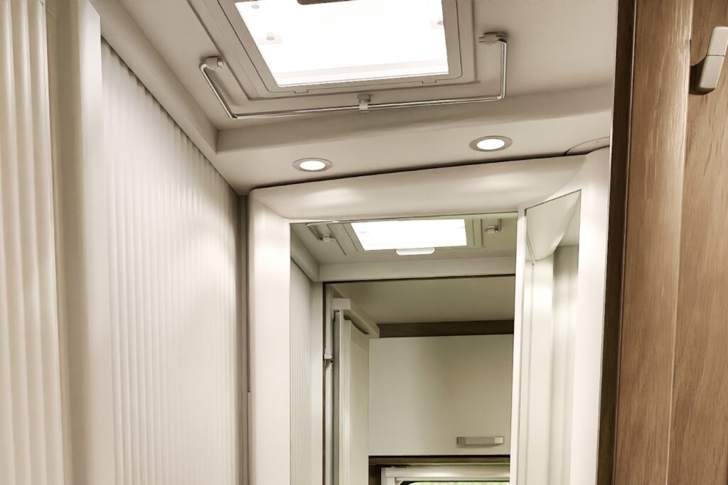 Badezimmer im Carado Wohnmobil mit Spiegel, Dachfenster und heller Schiebetür