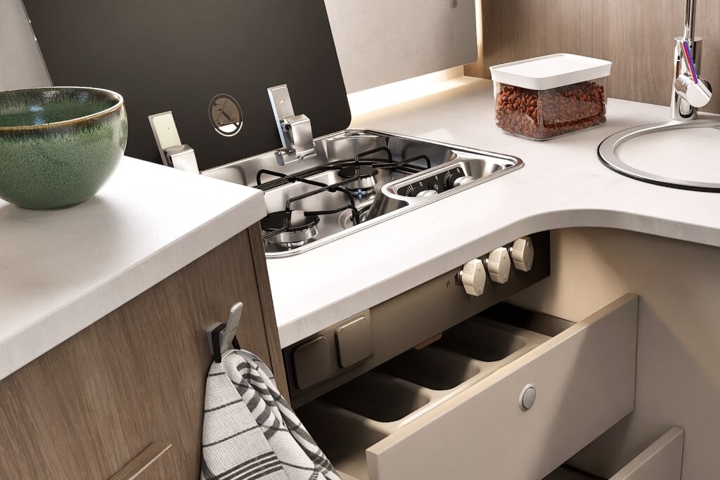 Carado motorhome interior with kitchen, gas hob, sink and an open drawer