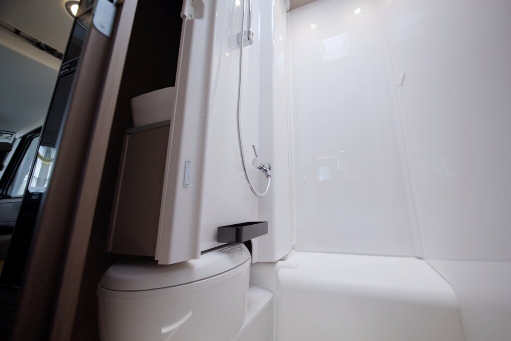 Bathroom in the Carado motorhome with shower cubicle, handheld showerhead and compact cassette toilet
