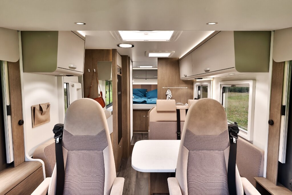 Carado motorhome interior with swivel front seats, dinette, roof windows and rear bed