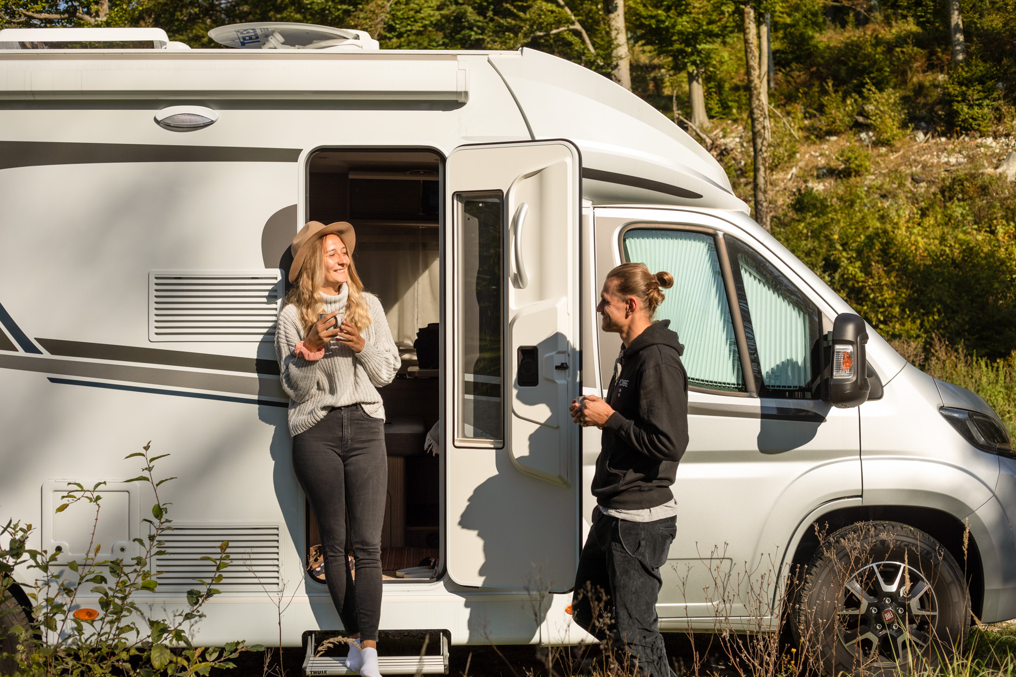 Die Reisenden stehen vor dem Carado Wohnmobil