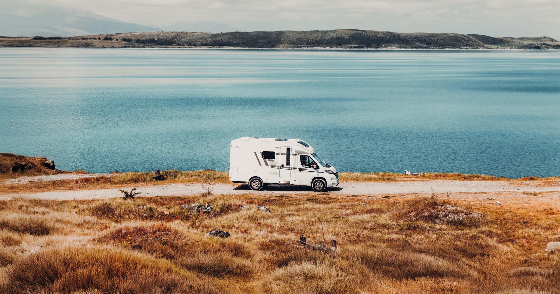 Reisemobil von Carado parkt in malerischer Natur, ideal für abenteuerliche Reisen und Entdeckungen in Europa.