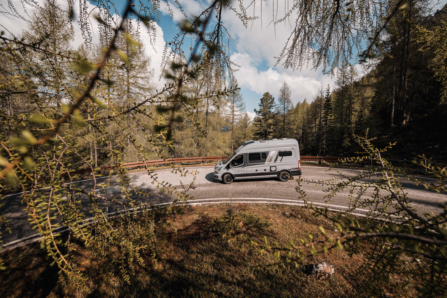 Camper Van 590 4x4 grau auf einer Straße im Wald